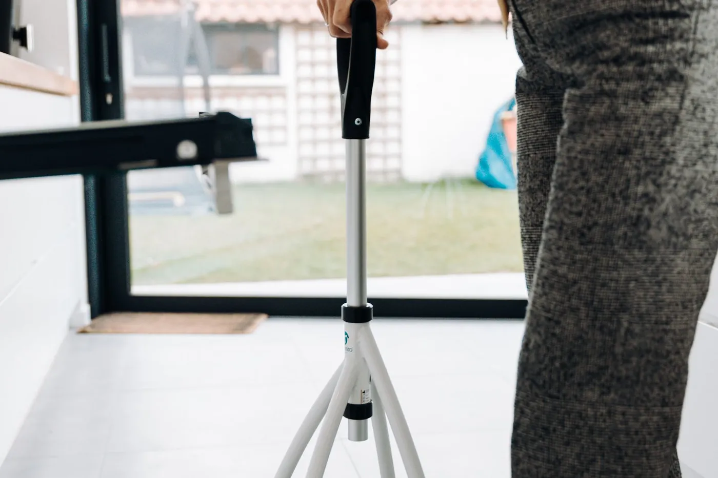 An older adult using a walker independently in a modern home kitchen.