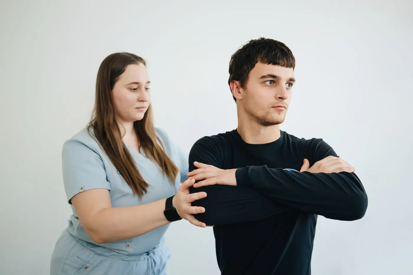 A physical therapist assisting a patient with arm rehabilitation exercises.