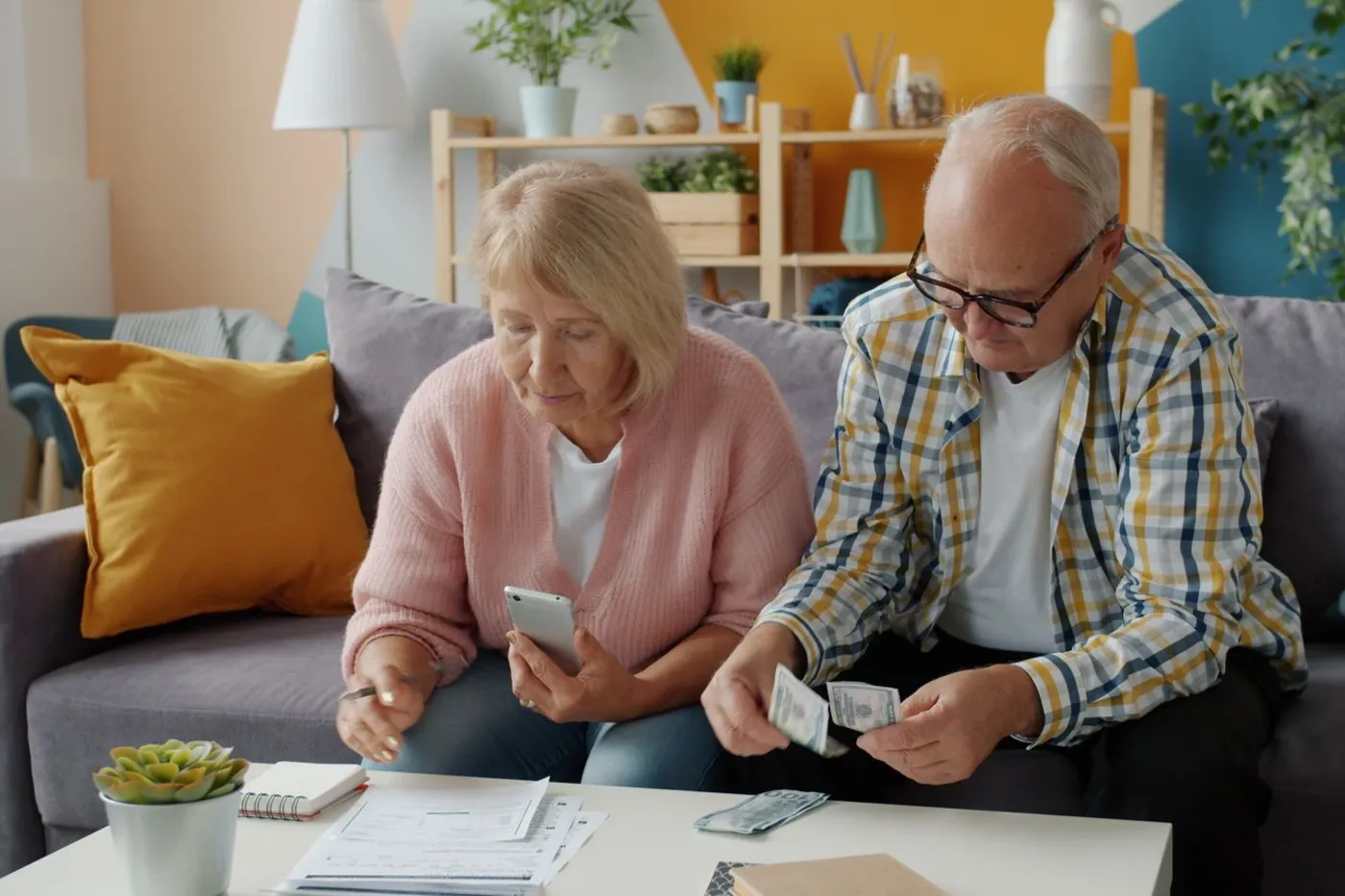 A senior couple budgeting together in their living room.
