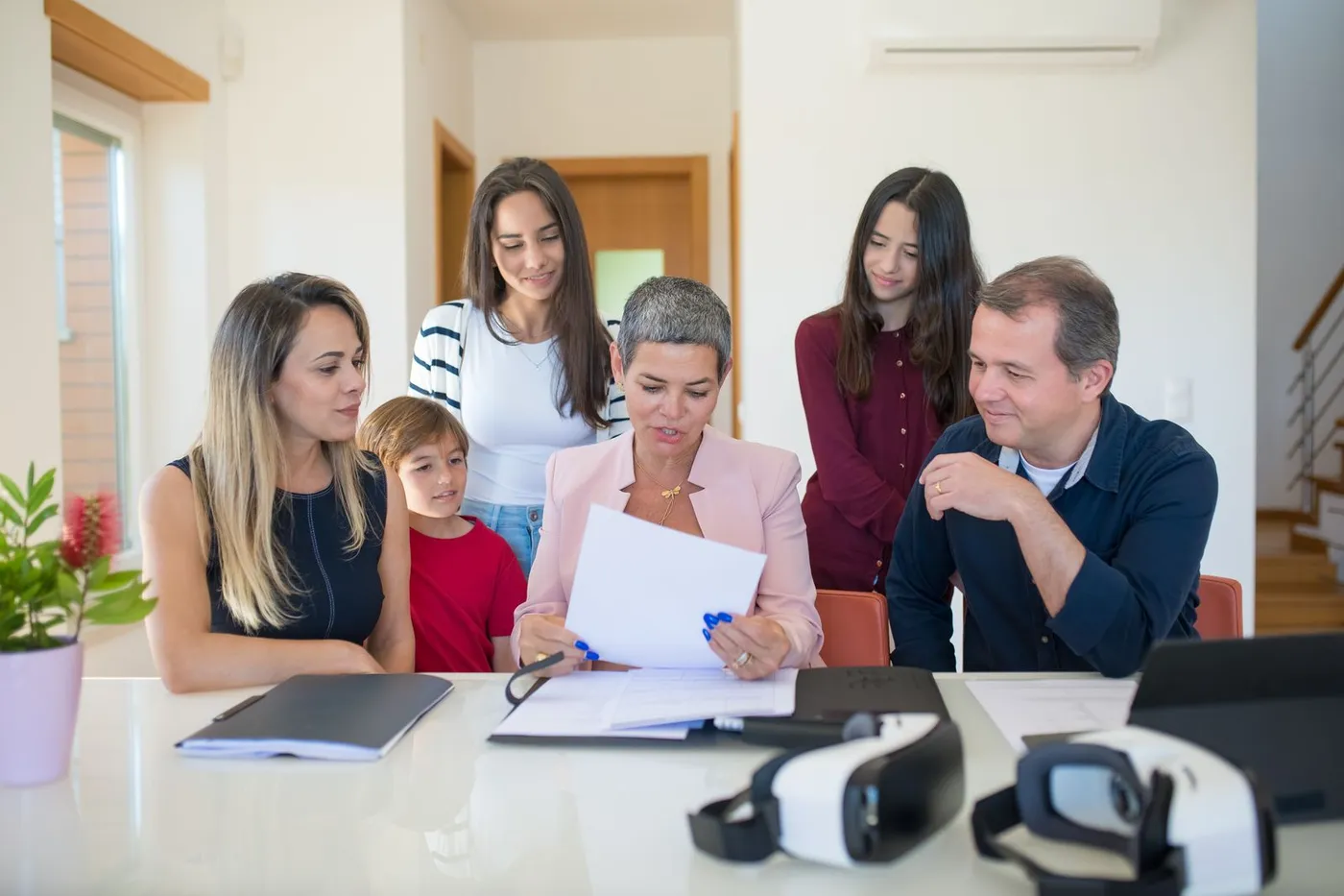 A family reviewing housing documents together at a table.