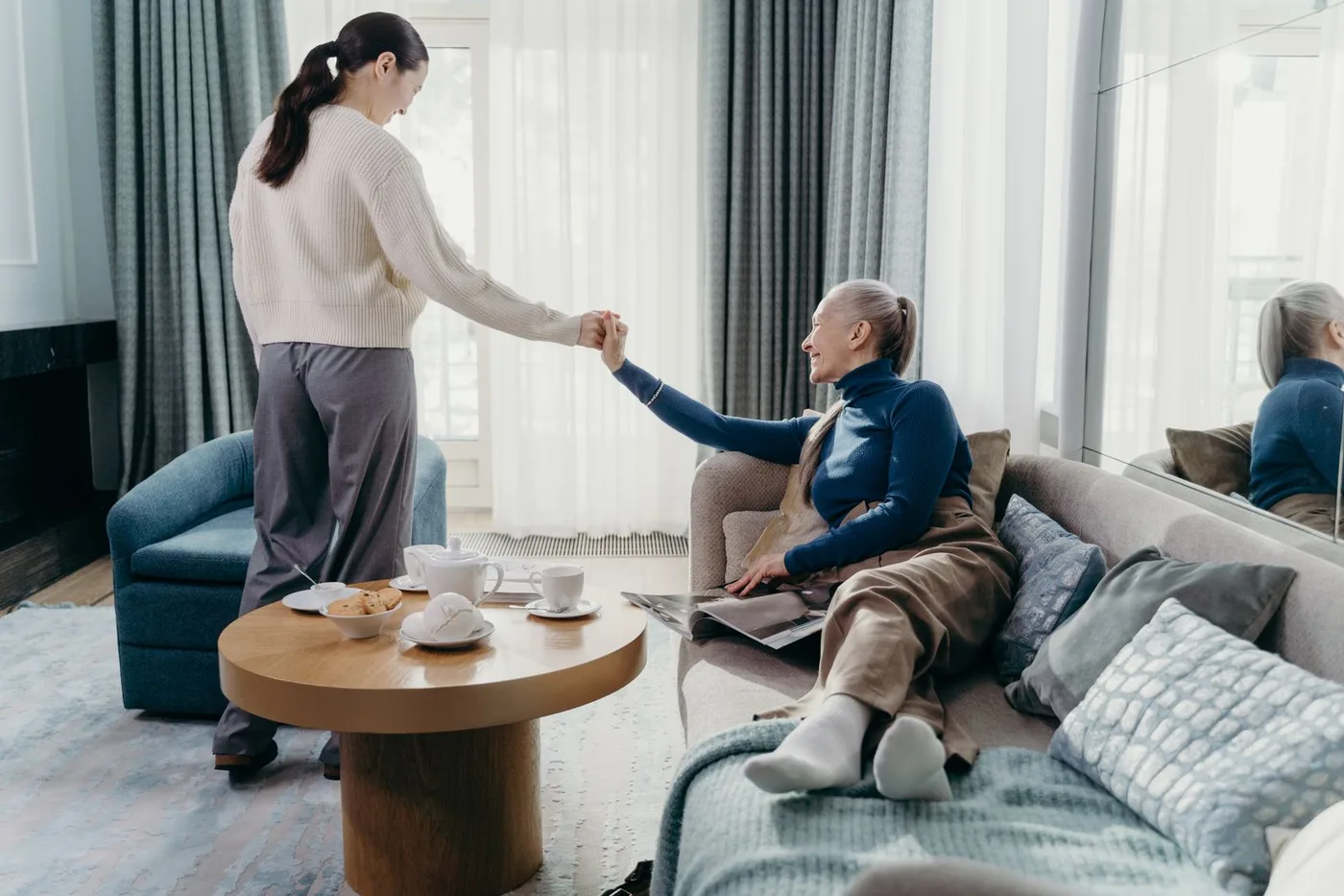 An older woman and her adult daughter spending quiet time together at home.