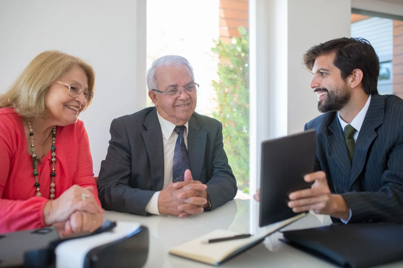 An older couple discussing home-financing paperwork with an advisor.