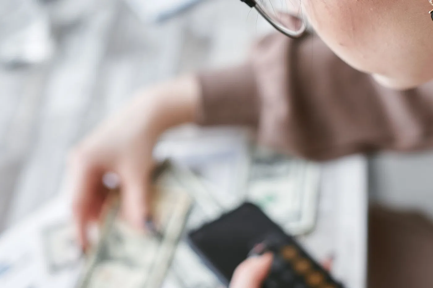Banknotes, a calculator, and printed documents laid out on a table.