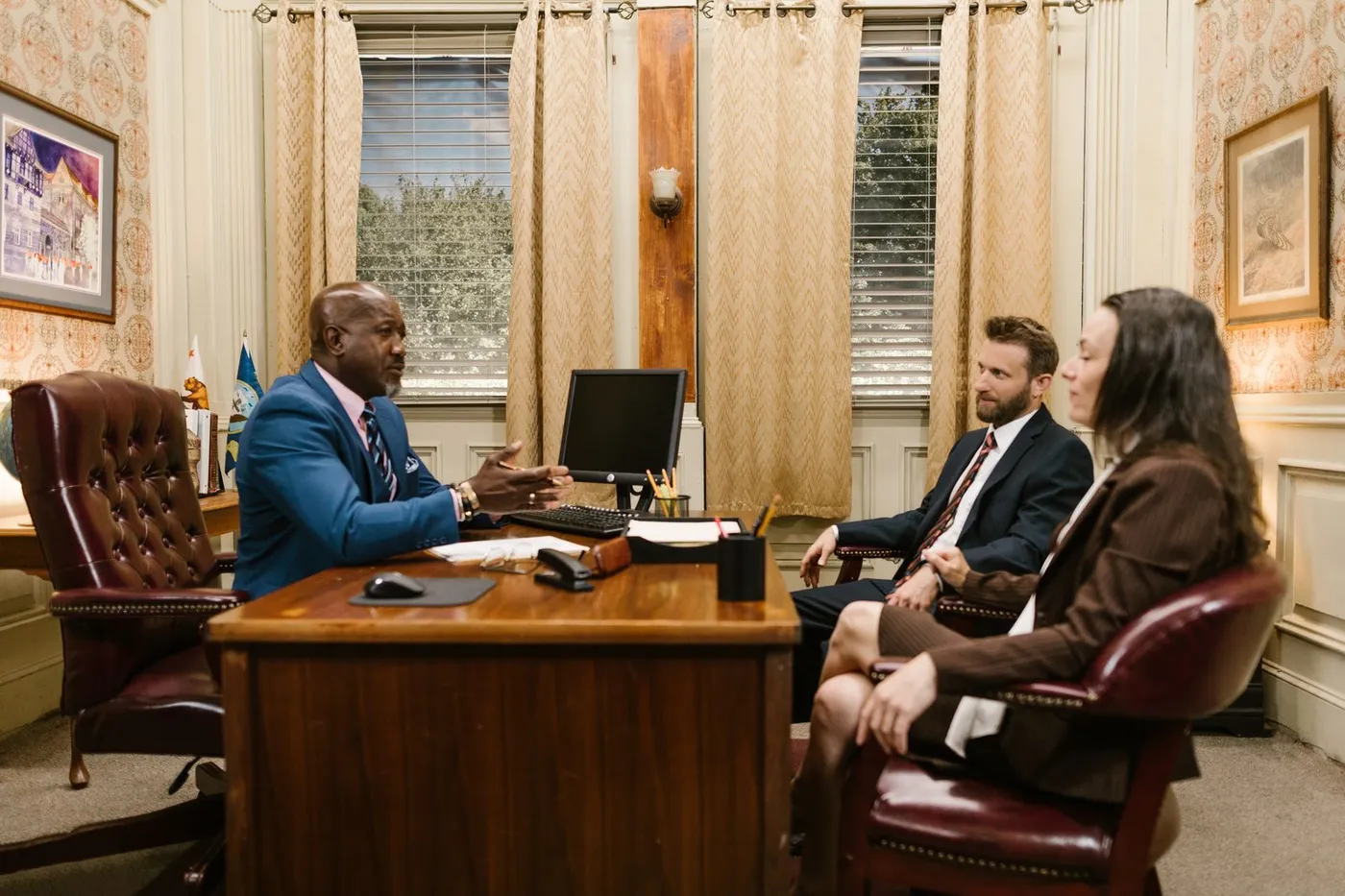 An adult meeting with an elder-law attorney across a desk to discuss legal options.