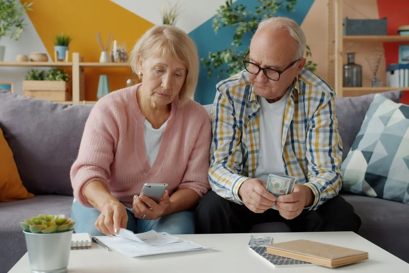 A senior couple going over household bills together in their living room.