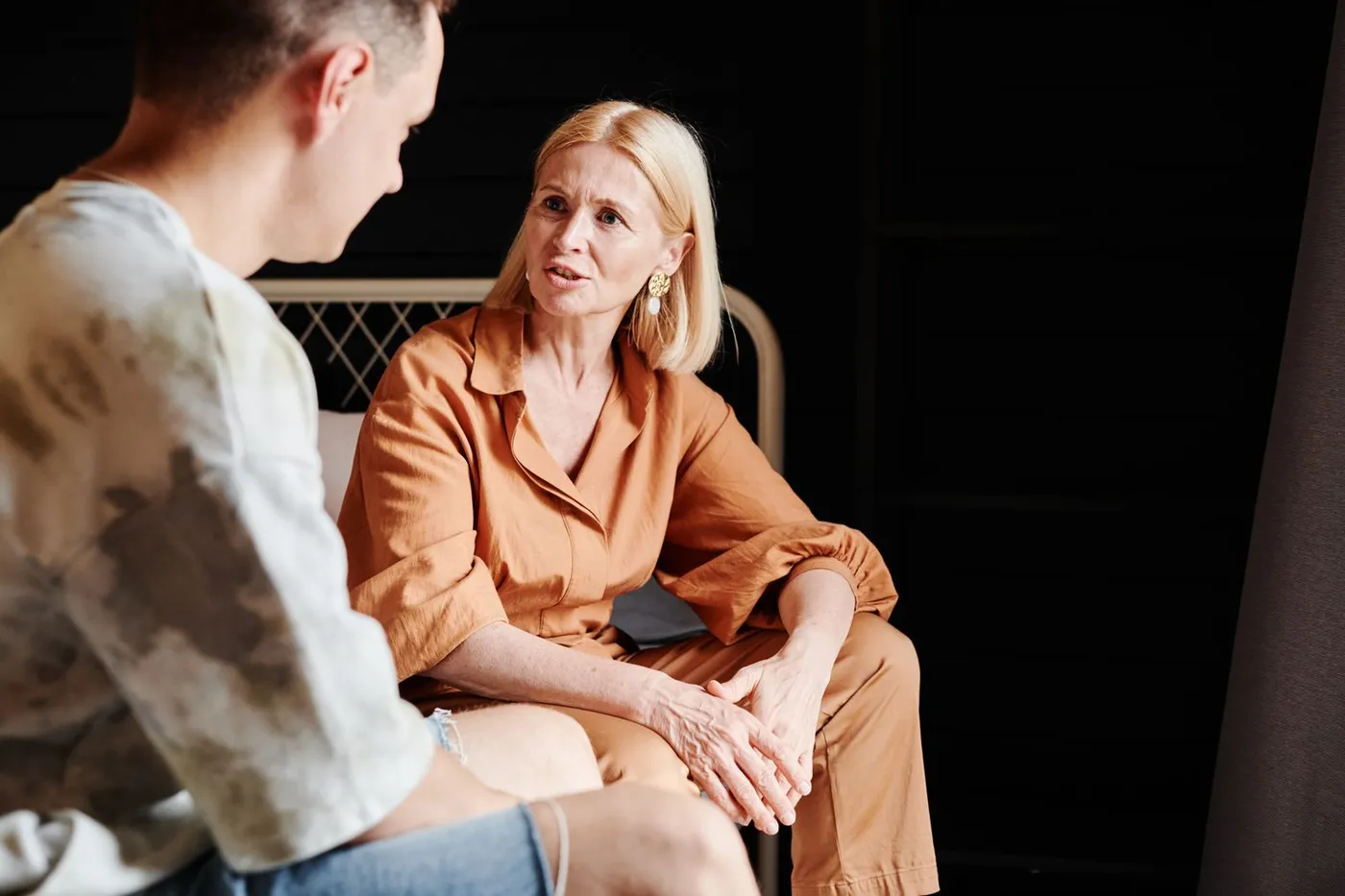 An adult son having a heartfelt conversation with his elderly parent at home.